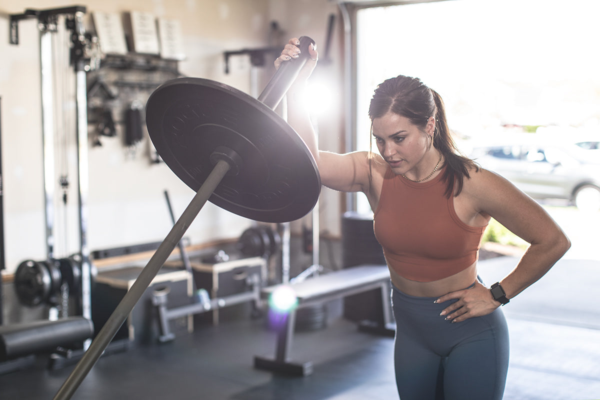 woman performing landmine exercises in her home gym