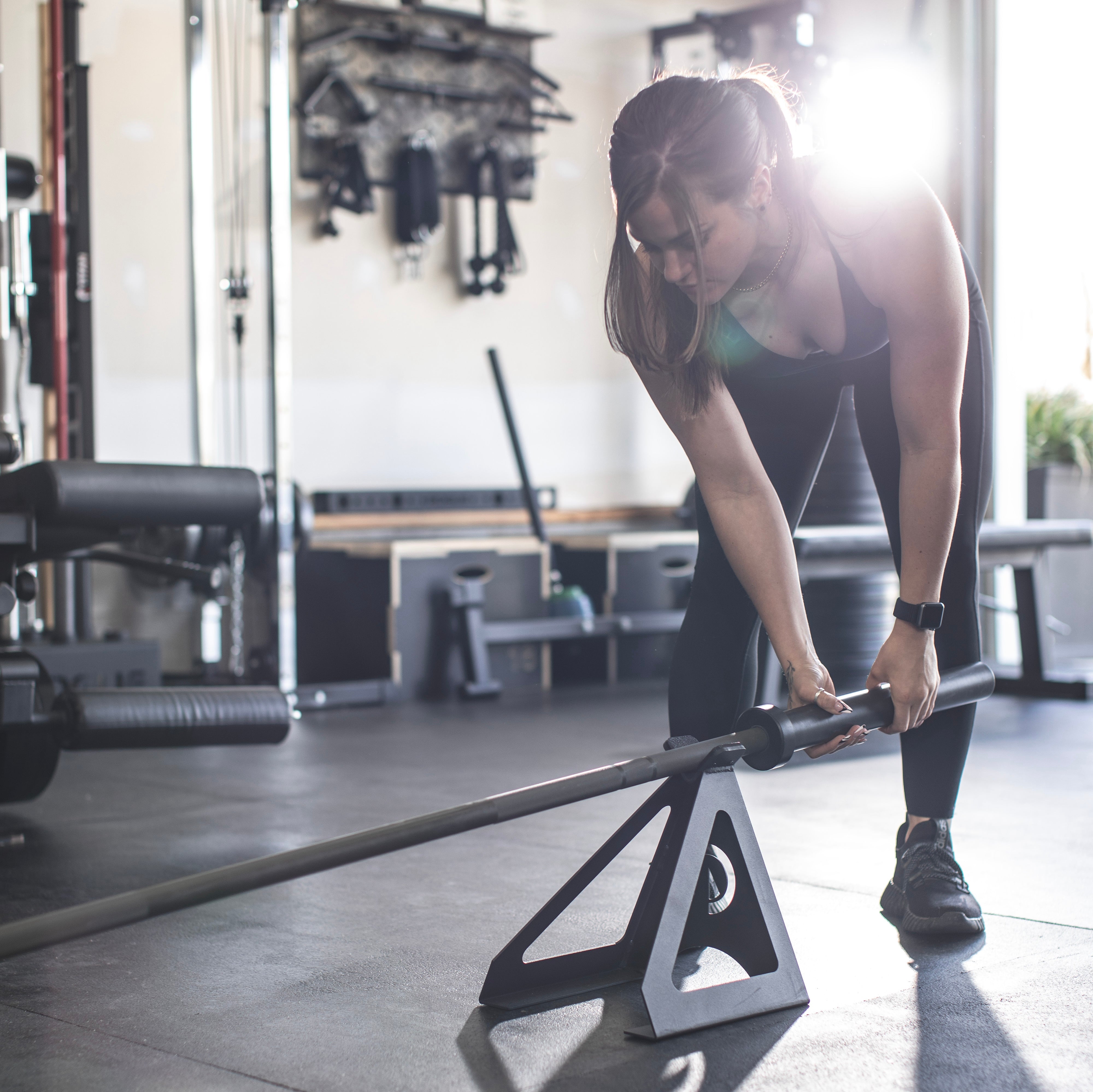 a women doing landmine workouts with a barbell