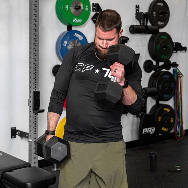 Lifter doing a bicep curl with a PRx straight handle hex dumbbell