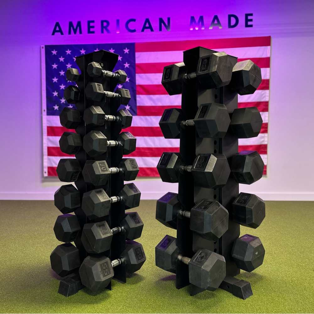 a black 10-tier vertical dumbbell rack placed next to a heavy duty black 5-tier vertical dumbbell rack both holding dumbbells.