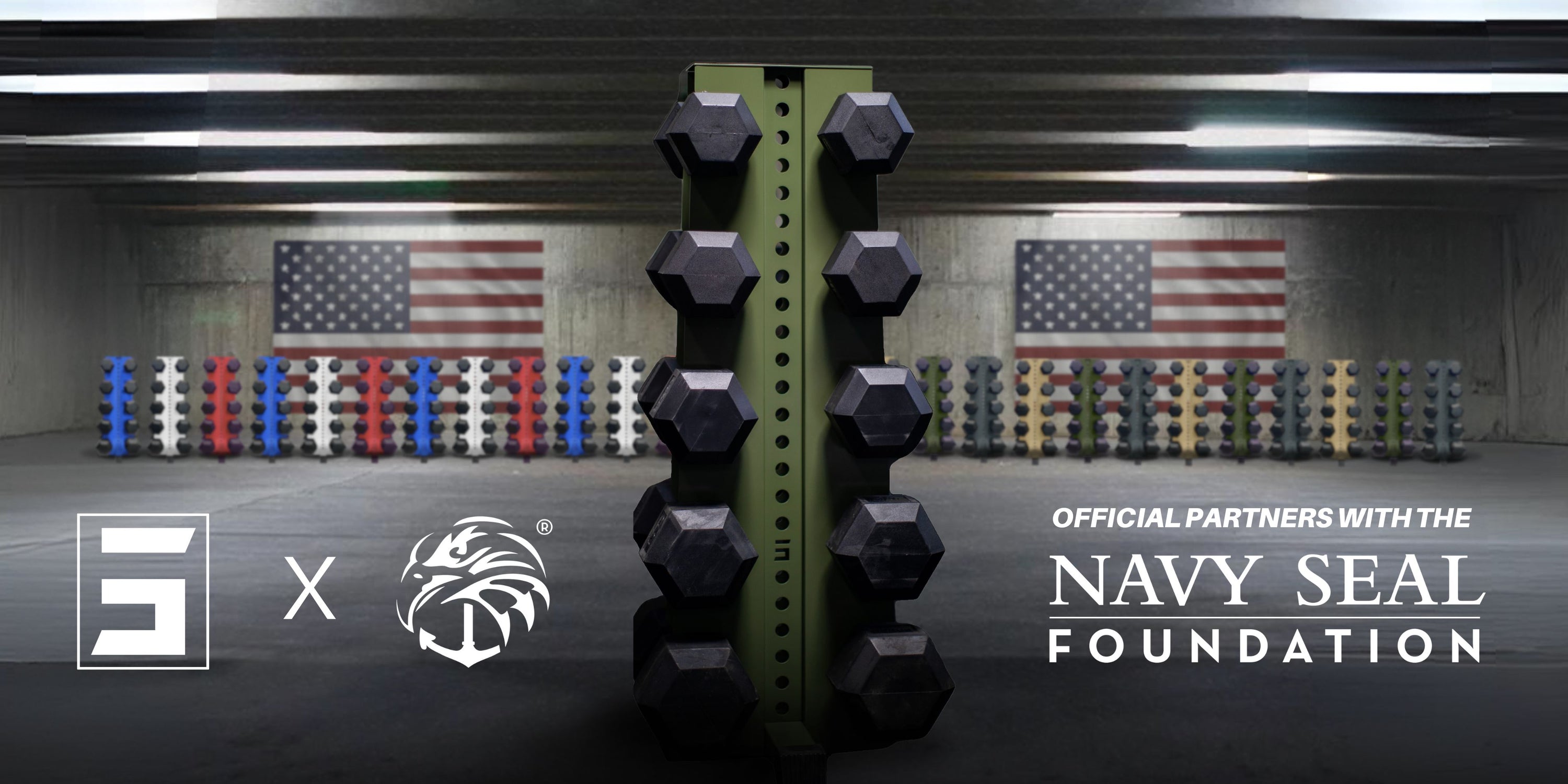 a 5-tier Synergy Custom Fitness military green vertical dumbbell rack holding dumbbells in a garage with American flags and several other vertical dumbbell racks in the background with text reading in the foreground, "official partners with the Navy Seal Foundation"